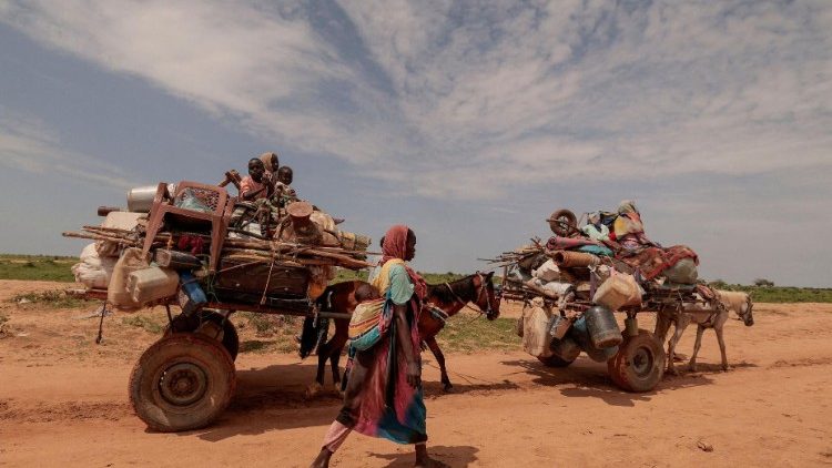 Uma mulher sudanesa, que fugiu do conflito em Murnei, na região sudanesa de Darfur, caminha ao lado de carroças carregando pertences de sua família ao cruzar a fronteira entre o Sudão e o Chade em Adre, Chade, 2 de agosto de 2023. REUTERS/Zohra Bensemra
