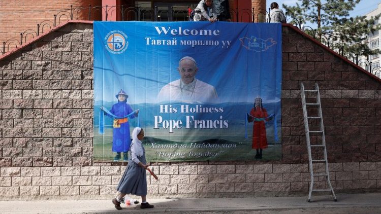 People install a poster with an image of Pope Francis outside the bishop’s house, where he is expected to stay during his Apostolic Journey, one day ahead of his arrival in Ulaanbaatar