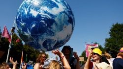 Climate activists juggle a giant inflatable blue planet