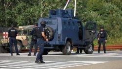 Kosovo police and U.S. and EU troops stand by after one police officer was killed, another hurt in Kosovo gunfire, in Josevik