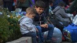 Crianças sentam na calçada enquanto moradores se reúnem no centro de Stepanakert para deixar Nagorno-Karabakh, uma região habitada por etnia armênia, 25 de setembro de 2023. REUTERS/David Ghahramanyan