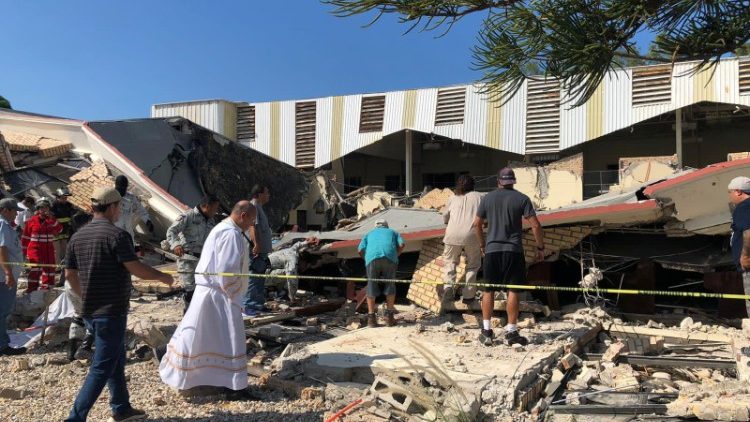 Miembros de las fuerzas de seguridad, personas y un sacerdote trabajan en el lugar donde se derrumbó el techo de una iglesia durante la misa dominical en Ciudad Madero, en el estado de Tamaulipas, México.