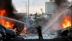 Záchranáři pracují na uhašení požáru po odpálení raket z pásma Gazy na snímku z města Aškelon v Izraeli 7. října 2023