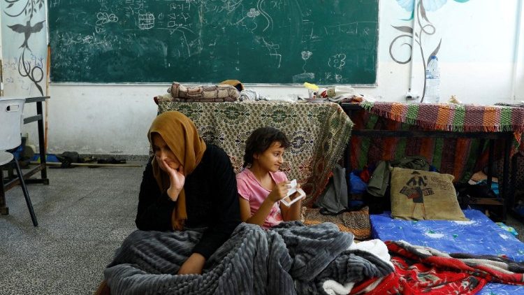 Familias palestinas que han perdido sus casas en los bombardeos israelíes se refugian en una escuela habilitada por la ONU en Khan Younis