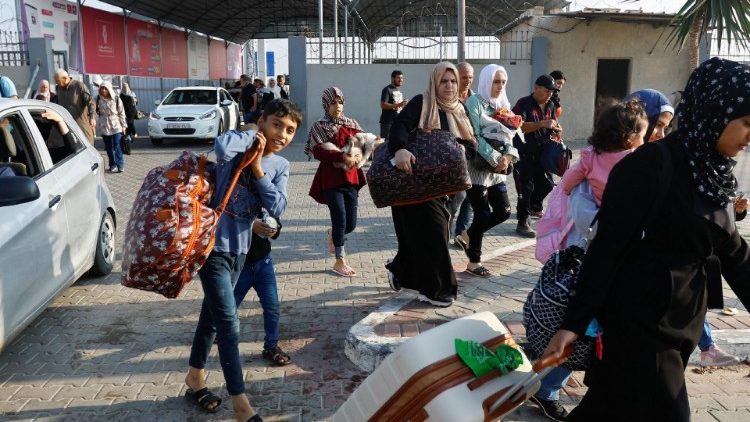 Palestinos con doble nacionalidad esperan permiso para salir de Gaza, en el paso fronterizo de Rafah con Egipto.