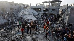 Palestinians search for casualties at the site of Israeli strikes on houses, at the Magazi Refugee Camp