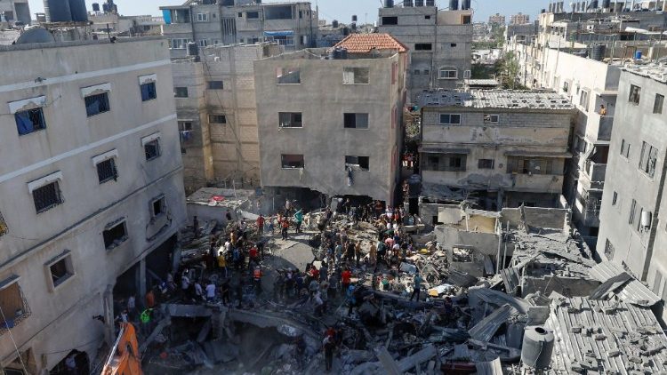 Palestinians gather at the site of an Israeli strike on a house