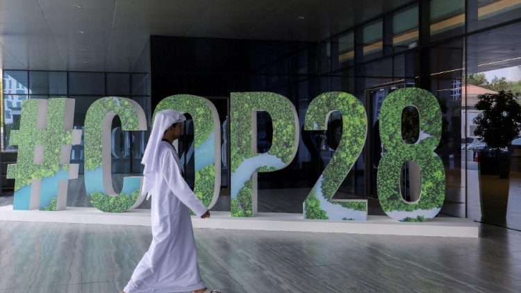 Une personne passe devant un panneau "#COP28" pendant le Changemaker Majlis, un atelier d'une journée destiné aux dirigeants d'entreprise et portant sur l'action climatique, à Abou Dhabi.