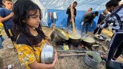 Az izraeli bombázások miatt otthonukat elhagyni kényszerült palesztin családok főznek