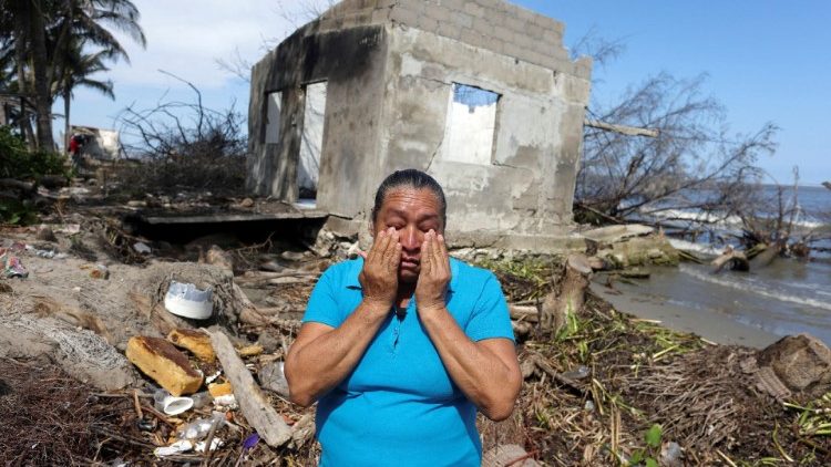 A Mexican woman cries in front of what is left of her house as rising sea levels destroy