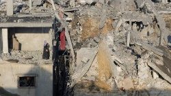 Palestinska žena stoji na ruševinama kuće u Khan Younisu
