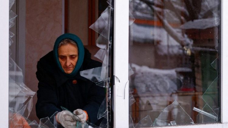 A moradora local Nadiia Matviienko remove pedaços de vidro de uma janela quebrada de sua casa danificada por um ataque de míssil russo, em meio ao ataque da Rússia à Ucrânia, em Kiev, Ucrânia, 11 de dezembro de 2023. REUTERS/Valentyn Ogirenko