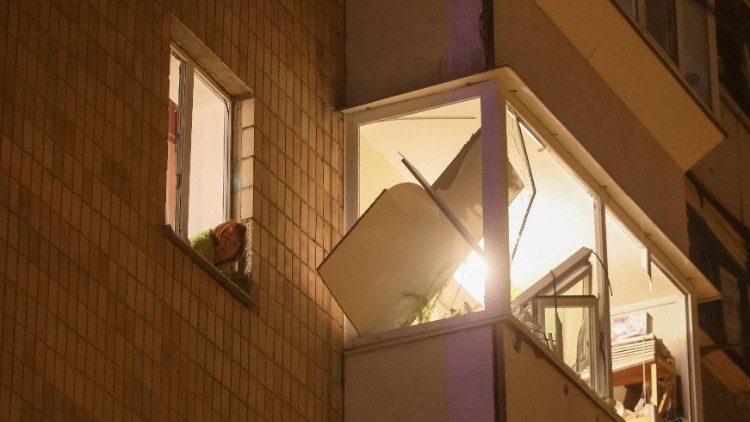 Uma moradora local olha pela janela de seu prédio danificado durante um ataque de míssil russo, em meio ao ataque da Rússia à Ucrânia, em Kiev, Ucrânia, 13 de dezembro de 2023. REUTERS/Gleb Garanich