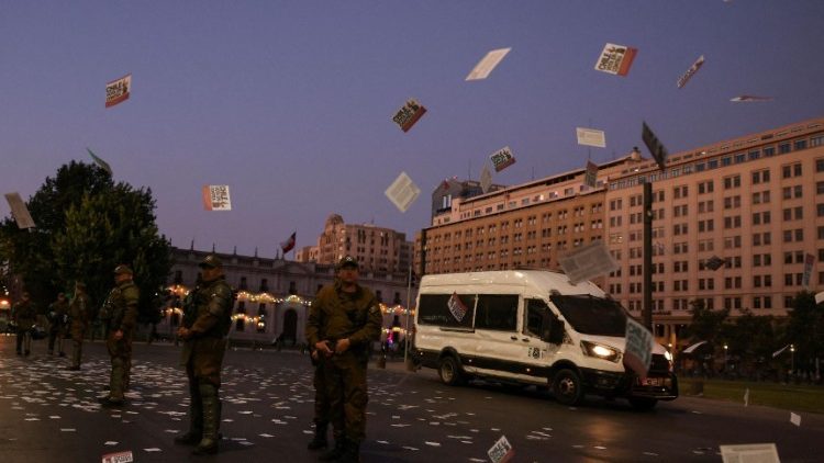 Brochures électorales volant au-dessus des forces de sécurité, le jour du référendum sur la nouvelle constitution chilienne, à Santiago du Chili, le 17 décembre 2023.