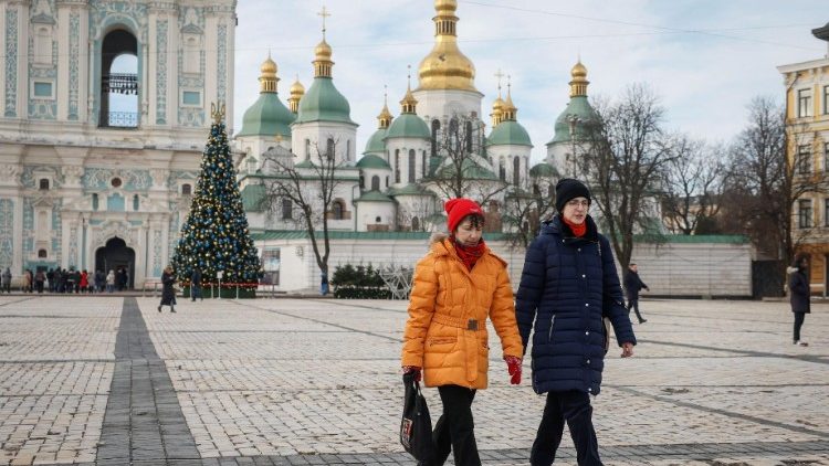 People walk near a Christmas tree in front of the Saint Sophia Cathedral in Kyiv, Ukraine