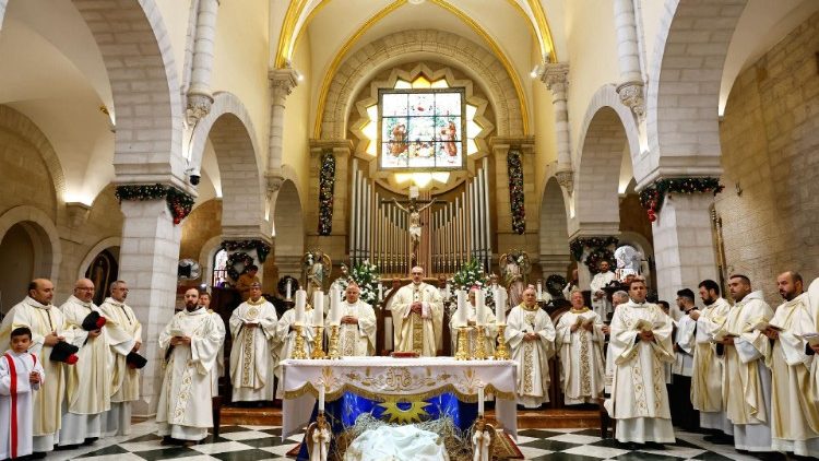L'altare, il celebrante e i concelebranti della Messa della notet di Natale a Betlemme. Al centro il patriarca Pizzaballa, accanto a lui, a sinistra il cardinale Krajewski, inviato di Papa Francesco