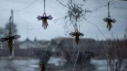 Estatuetas de anjos são vistas na vitrine de um supermercado local quebrada por estilhaços na região de Kharkiv. (REUTERS/Viacheslav Ratynskyi)