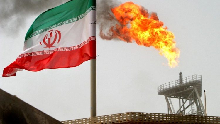 FILE PHOTO: A gas flare on an oil production platform is seen alongside an Iranian flag in the Gulf