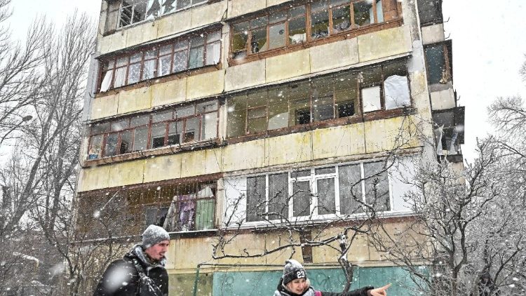 Voluntários conversam ao lado de um prédio de apartamentos danificado no local de um ataque com mísseis russos, em meio ao ataque da Rússia à Ucrânia, em Zaporizhzhia, Ucrânia, em 8 de janeiro de 2024. REUTERS/Stringer