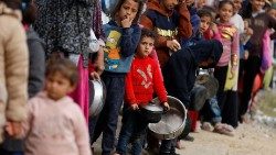 Palestinians wait to receive food amid shortages of food supplies, in Rafah