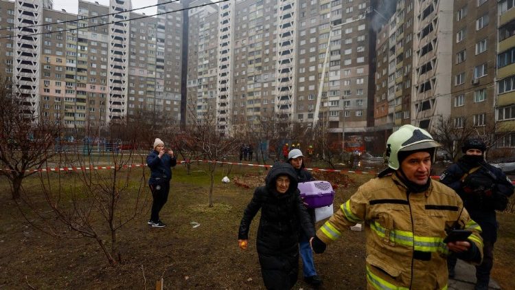Uma equipe de resgate ajuda uma mulher em um prédio danificado durante um ataque com míssil russo, em meio ao ataque da Rússia à Ucrânia, em Kiev, Ucrânia, 7 de fevereiro de 2024. REUTERS/Valentyn Ogirenko