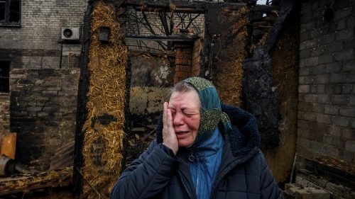 Ucraniana chora ao homenagear família  de dois adultos e três crianças, mortos na sexta-feira, 9 de fevereiro, em sua casa que pegou fogo em um ataque de drone russo em Kharkiv, Ucrânia, 12 de fevereiro, 2024. REUTERS/Vladyslav Musiienko
