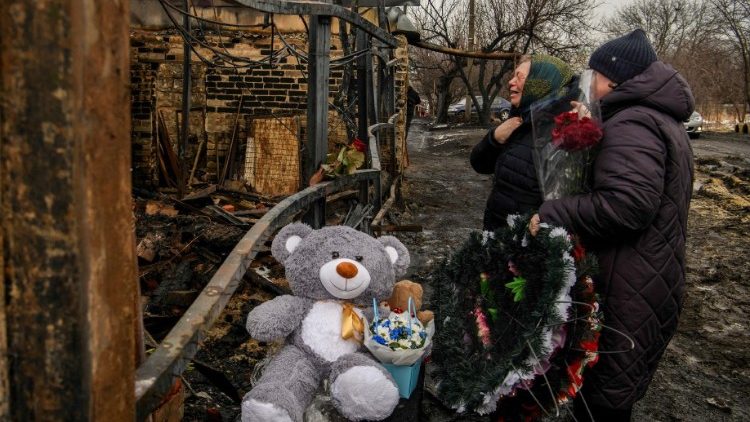 Pessoas choram ao recordar uma família de dois adultos e três crianças, residentes locais que foram mortos na sexta-feira, 9 de fevereiro, em sua casa que pegou fogo em um ataque de drone russo em Kharkiv, Ucrânia, 12 de fevereiro de 2024 .REUTERS/Vladyslav Musiienko
