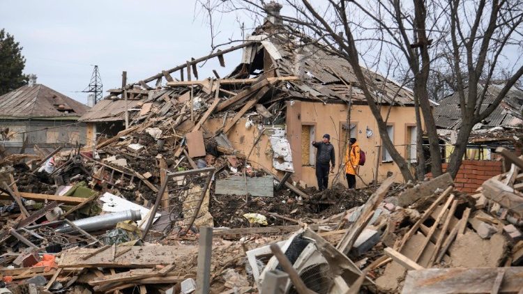 Moradores locais ficam ao lado de um prédio fortemente danificado por um ataque de míssil russo, em meio ao ataque da Rússia à Ucrânia, na cidade de Chuhuiv, região de Kharkiv, Ucrânia, 15 de fevereiro de 2024. REUTERS/Vladyslav Musiienko