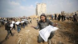 Palestyńczycy noszący worki z mąką otrzymane w ramach pomocy humanitarnej w Strefie Gazy, 19 lutego 2024 r.