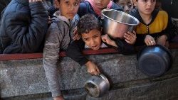  रफ़ाह में एक चारिटी रसोई द्वारा पकाए गए भोजन का इंतज़ार कर रहे फ़िलिस्तीनी बच्चे