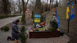 Kobieta modląca się przy grobie żołnierza, Kijów, 7 marca 2024 r.