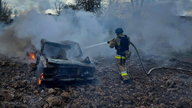 Um bombeiro apaga o fogo em um carro destruído durante um ataque com míssil russo, em meio ao ataque da Rússia à Ucrânia, em Mykolaiv, Ucrânia, em 17 de março de 2024. Press service of the State Emergency Service of Ukraine in Mykolaiv region/Handout via REUTERS 