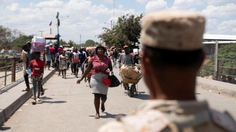Ciudadanos haitianos transportan productos comprados en la frontera entre República Dominicana y  Haití, mientras continúa la violencia en el país.