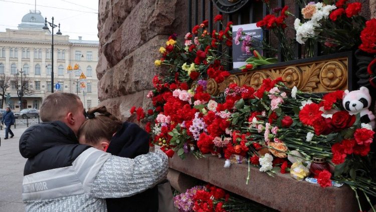 A couple hugs near a makeshift memorial in St. Petersburg