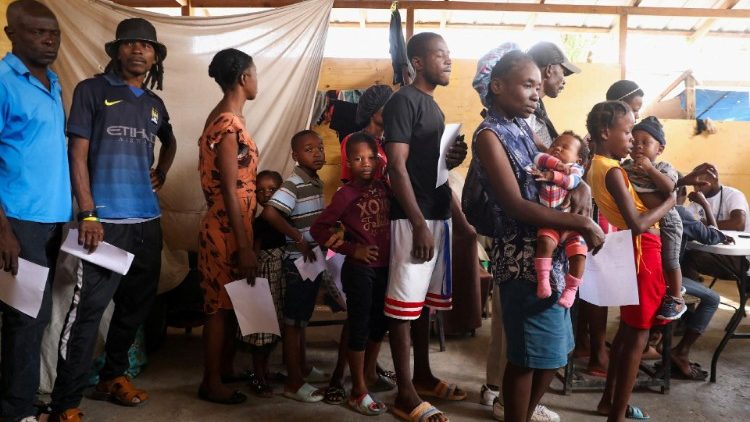 Personas esperan en fila ser atendidas en el hospital móvil organizado por la UNICEF y Médicos del Mundo para los desplazados por la violencia en Puerto Príncipe