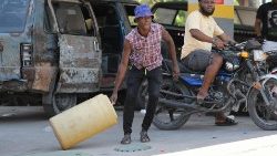 A man drags a container at a petrol station as violence spreads and armed gangs expand their control over the capital, in Port-au-Prince.