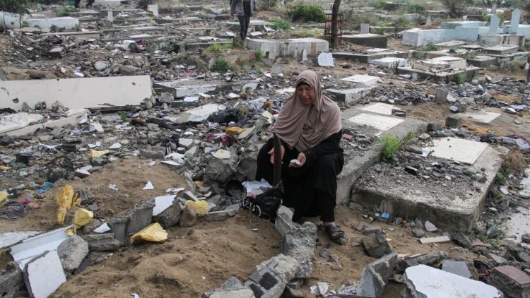 A Palestinian visits the graves of people killed in the ogoing conflict