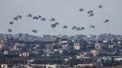 Humanitarian aid falls through the sky towards the Gaza Strip, as seen from Israel