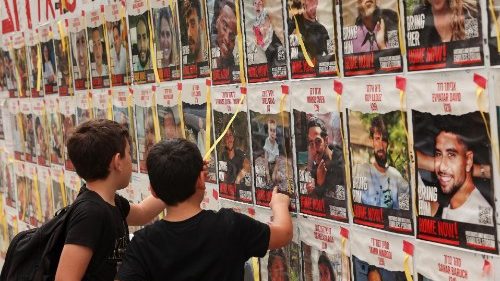 Kinder vor einer Plakatwand in Tel Aviv, die Fotos der bei der Hamas-Attacke vom 7. Oktober genommenen Geiseln zeigt
