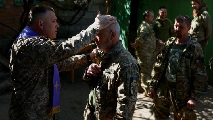 A priest blesses soldiers after Divine Liturgy near the front lines