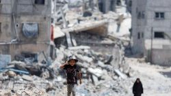 Palestinos caminan junto a casas destruidas en un ataque israelí, en medio del actual conflicto entre Israel y Hamás