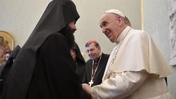 Pope Francis shakes hands with a member of the Orthodox delegation