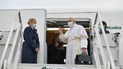 Pope Francis waves as he boards the papal plane