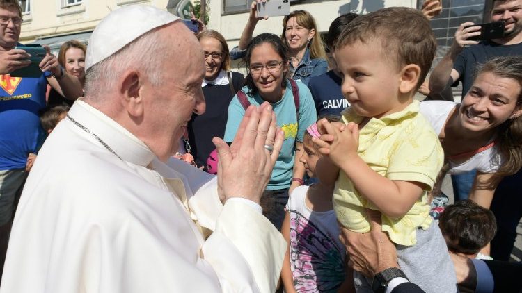 Pope Francis shows a Slovak child how to fold his hands in prayer
