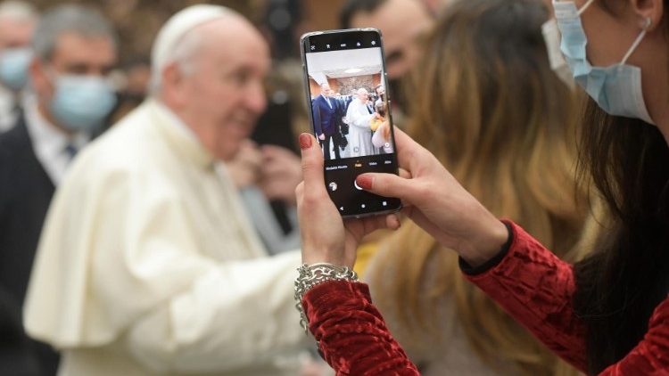 A woman records a video of the Pope at an audience with the Dicastery for Communication