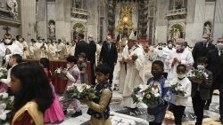 Le Pape, entouré par des enfants, amène l'Enfant Jésus vers la crèche de la basilique Saint-Pierre, au terme de la nuit de Noël du 24 décembre 2021.