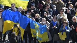 Des fidèles brandissant le drapeau ukrainien dimanche 6 mars 2022 place Saint-Pierre.