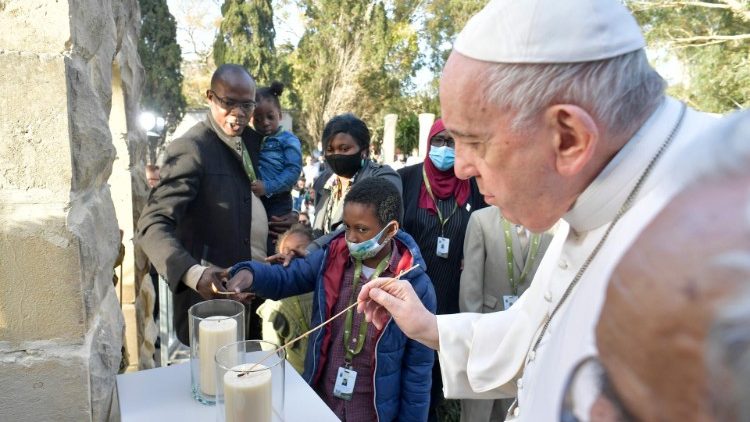 Pope Francis joins others in lighting a candle, symbol of faith and hope