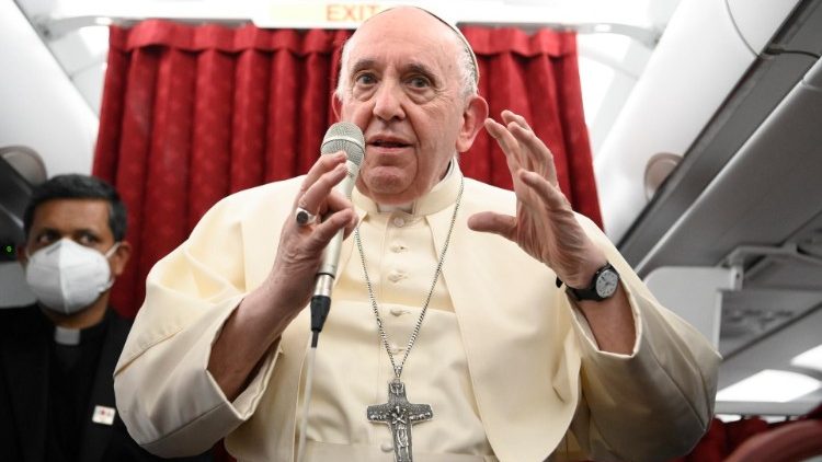 Pope Francis answers questions during an inflight press conference from Malta