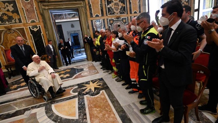Voluntario de la Protección civil italiana aplauden al Papa a su llegada a la Sala Clementina del Vaticano
